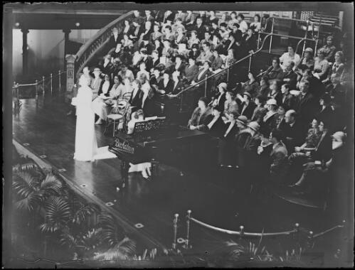 Miss Elsa Corry singing onstage to an audience accompanied by a pianist, Town Hall, Sydney, New South Wales, 13 April, 1934 [picture]