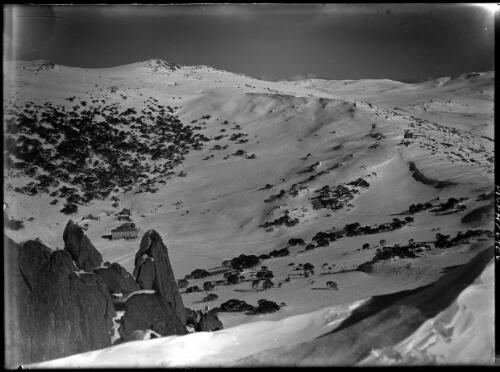 [Main range from Charlotte Pass, chalet and other buildings to the left] [picture] : [Kosciuszko, New South Wales] / [Frank Hurley]