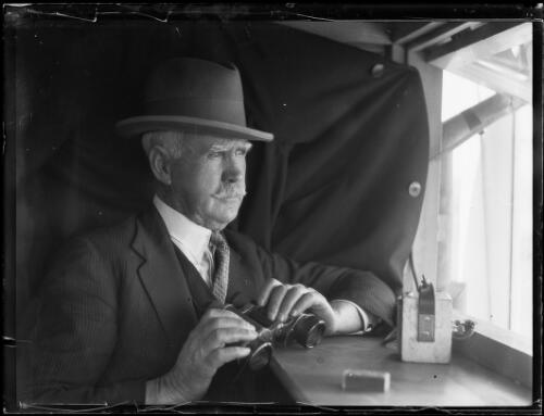 Mick Kerry holding binoculars at a racecourse, New South Wales, ca. 1930s, 1 [picture]