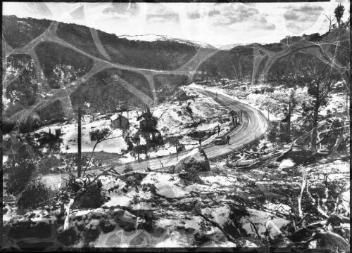 [A car and a figure on a road through the mountains] [picture] : [Snowy Mountains Hydro-Electric Scheme, New South Wales] / [Frank Hurley]