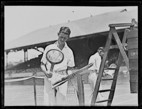 Tennis player R.O. Cummings examining racquets, New South Wales, ca. 1926 [picture]