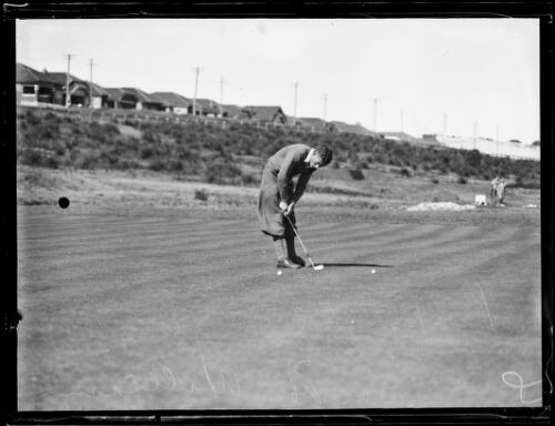 Amateur golfer H. Williams putting a golf ball into a hole, New South Wales, ca. 1930s [picture]