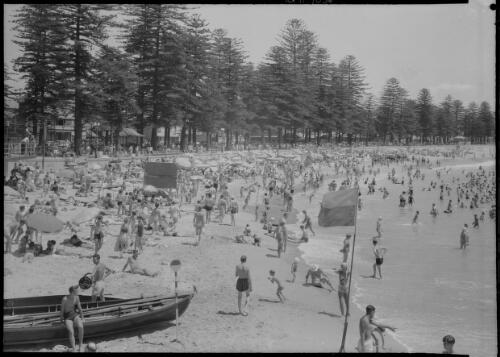 [Crowded beach scene with lifesavers and boats, Manly, 1] [picture] : [Sydney, New South Wales] / [Frank Hurley]