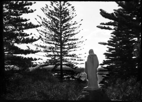 Manly St Patrick's [statue overlooking college grounds and water] [picture] : [Manly, New South Wales] / [Frank Hurley]