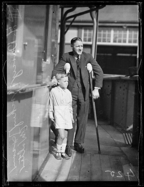 Jockey J. Darcy on crutches with his son Walter, New South Wales, ca. 1930s [picture]