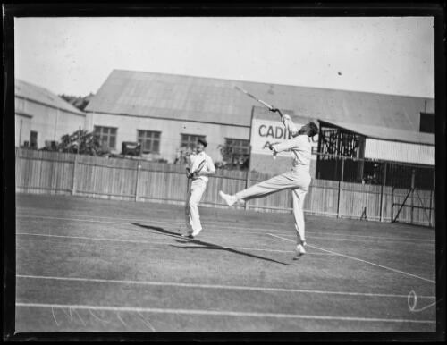 W.B. Walker jumping to return the ball in a doubles tennis game, New South Wales, ca. 1930s [picture]