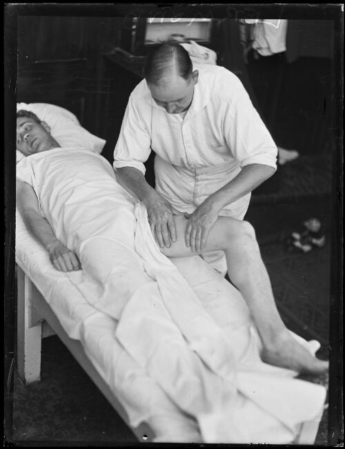 German athlete Leo Lermond receiving treatment on his leg by man at Petty's Hotel [?], New South Wales, 11 January 1930, 1 [picture]