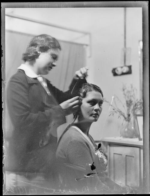 Swimmer Clare Dennis having her hair done by an unidentified woman, New South Wales, ca. 1932 [picture]