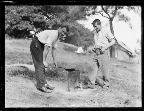 Two unemployed men cooking a meal over a fire during the Great Depression, Domain Park, Sydney, 1 September 1932 [picture]