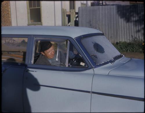 [Unidentified man sitting in a pale blue Holden? station wagon, Northern Queensland] [transparency] / [Frank Hurley]