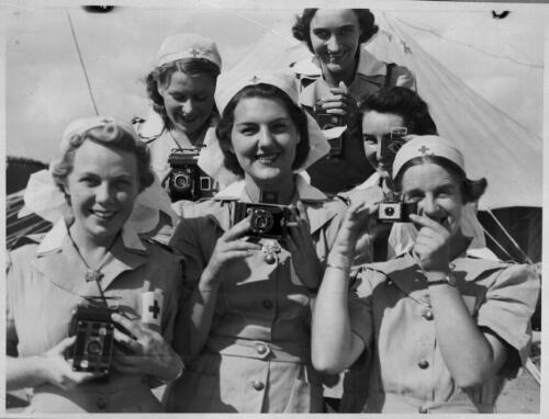 [Six smiling women in nurses' uniforms, each with a camera] [picture] / [Frank Hurley]