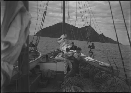 A crayfishing boat heading up for the shelter of Maatsuyker Island, southwest coast, with three men, Tasmania, 1939?, 2 [picture] / [Frank Hurley]