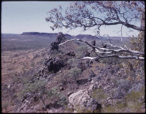 [Rocky spur with mountains in the background, Northern Territory] [transparency] / [Frank Hurley]