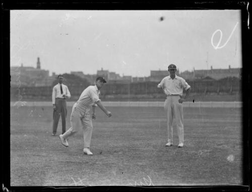 Cricketer Clarence Grimmet bowling a ball with two men behind him, New South Wales, ca. 1930 [picture]