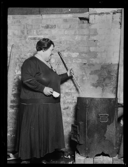 Woman stirring a metal pot at the Redfern Fish Markets during the Great Depression, Sydney, 29 May 1932 [picture]