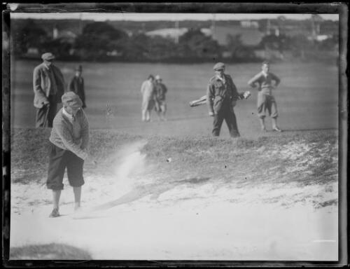 Golfer C.H. Fawcett hitting a ball out of sand bunker with a group watching, New South Wales, ca. 1920 [picture]