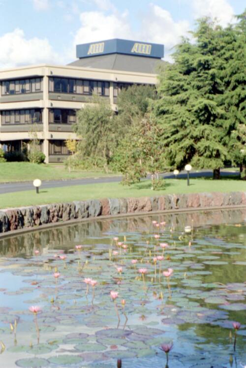 Exterior view of AHI and pond with water lillies in foreground, ACI, New Zealand, 1982 [picture] / Wolfgang Sievers