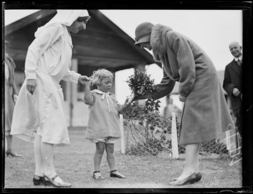 Young child being given flowers by a woman at Furlough House, Narrabeen, New South Wales, 19 September 1930 [picture]