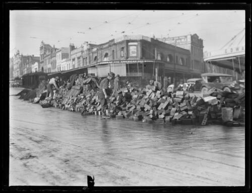 Timber setts piled on the road for roadwork repair in way of the tramlines, Oxford Street, Sydney, ca. 1920s [picture]