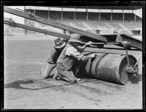 Two men examining a roller at the Sydney Cricket Ground during the preparation for the visiting English team, Sydney, 23 November 1932 [picture] / Baden H. Mullaney