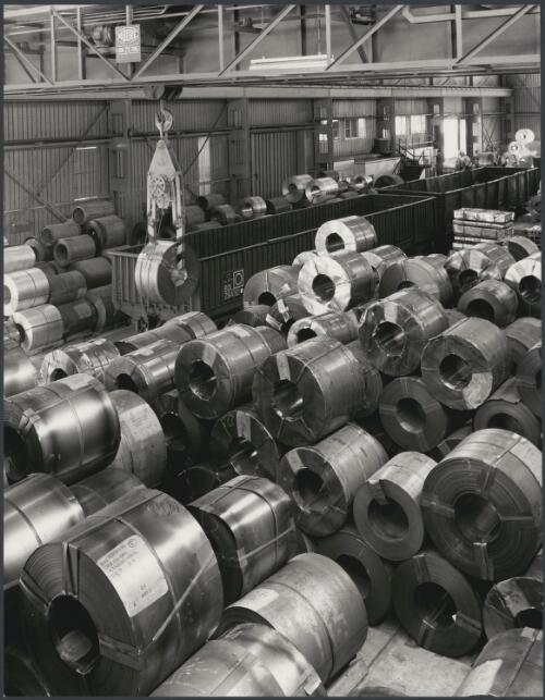 Rolls of sheet metal on factory floor, John Lysaght factory, Sunshine, Victoria, 1966 [picture] / Wolfgang Sievers