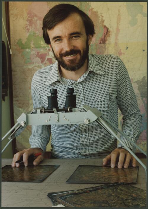 Geologist examining aerial survey photographs in Mt. Isa, Queensland, 2 [picture] / Wolfgang Sievers