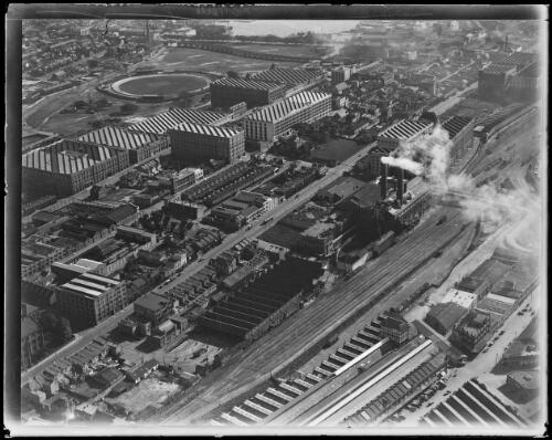 Aerial view looking west showing Darling Harbour goods yard and power station, tram shed, wool stores, Wentworth Park dog track in Glebe, Metropolitan Goods Lines railway and Blackwattle Bay, Sydney, 1932 [picture] / Baden H. Mullaney