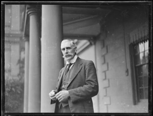 Mr. A.J.C. Christie outside the Sydney Mint holding pocket watch, Sydney, ca. 1930s, 2 [picture]