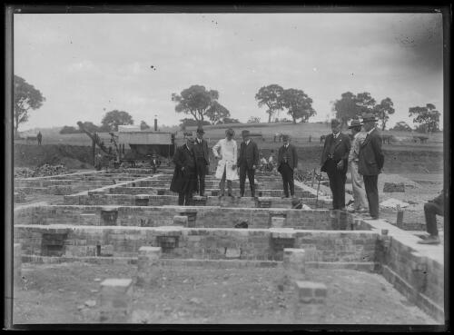 Members of the federal cabinet standing on the newly laid foundations of Parliament House, Canberra, ca. 1924 [picture]