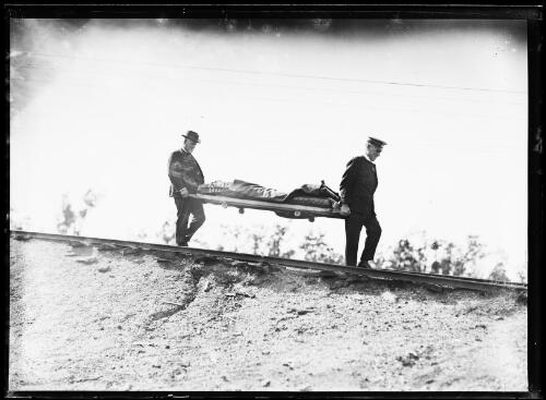 Two men carrying a stretcher at Bellbird Colliery, New South Wales, ca. 1920s [picture]