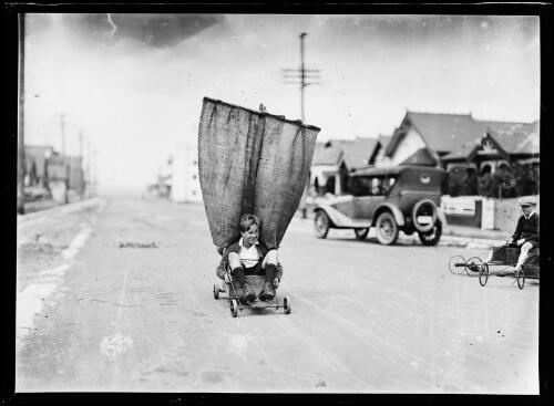 Boy riding a homemade land yacht down a suburban street, New South Wales, ca. 1930 [picture]