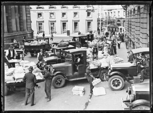 Sun Herald newspapers being loaded onto lorries, O'Connell Street, Sydney, ca. 1920s [picture]