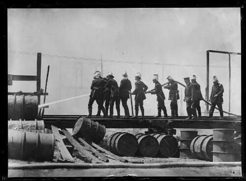 Firefighters standing along a railway line with a hose, New South Wales, ca. 1930s [picture]