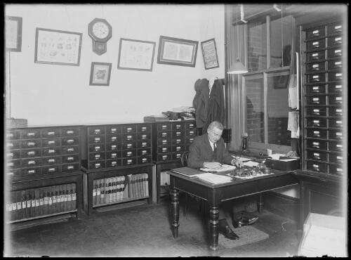 Inspector Perkins of the Finger Print Department examines work in his office, New South Wales, ca 1920 [picture]