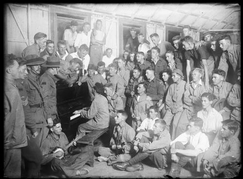Australian and foreign soldiers surrounding a soldier playing the piano, New South Wales, ca. 1918 [picture]