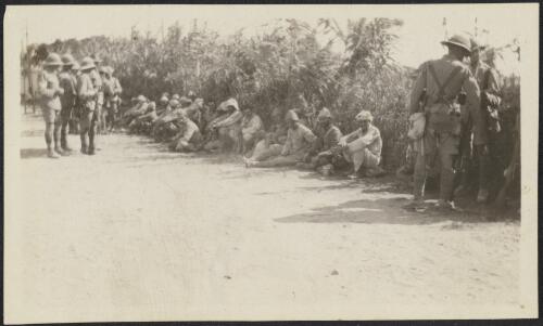 Turkish prisoners seated along a road and guarded by British Empire soldiers, Gaza Strip, 1917