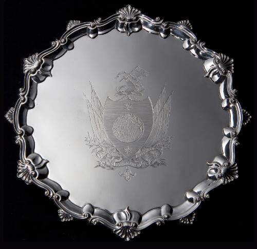 [A George III silver salver engraved with coat of arms of Captain James Cook] [cartographic material] : [incorporating a terrestrial globe centred on the Pacific Ocean between two pole stars on a shield, the crest of an arm embowed in naval uniform holding a Union flag with the motto "Circa orbem", the motto "Nil intentatem reliquit" below]
