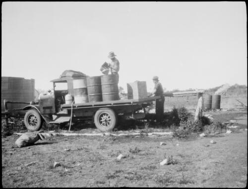 Carting water, filling containers on back of truck, Cosmo Newbery Station, Laverton, Western Australia, approximately 1934 / Michael Terry