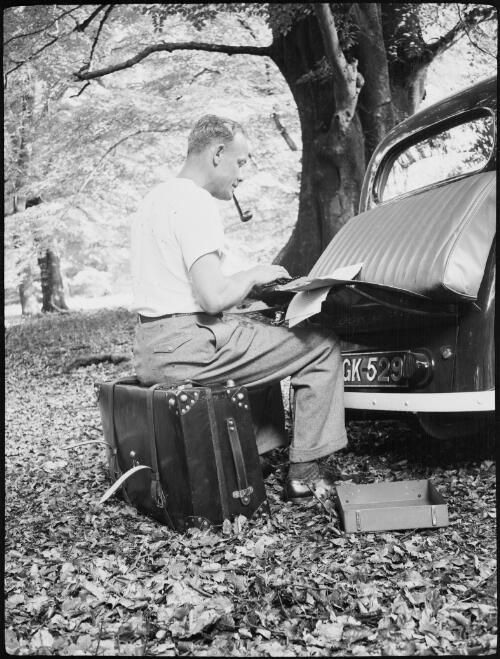 Michael Terry typing at the back of the car, England, 1940 / Michael Terry