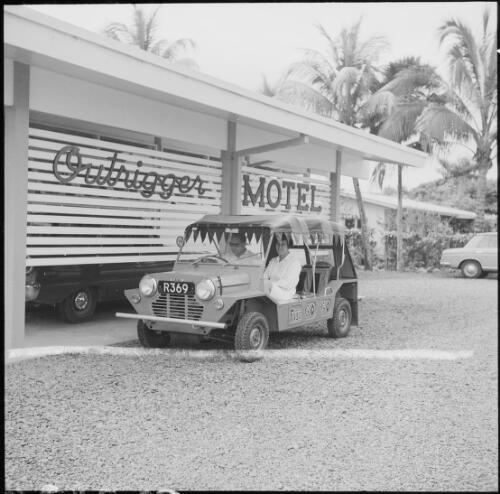 A man and a women sitting in a Mini Moke beside the Outrigger Motel, Fiji, November 1966 / Michael Terry