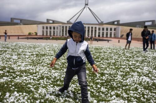 Four year old tourist from Melbourne Abofazl Mobarez playing in front of Parliament House after a hailstorm, Canberra, Australian Capital Territory, 20 January 2020 / Sean Davey