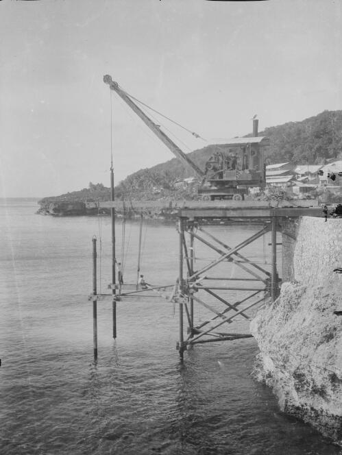 Workmen and crane during the construction of Christmas Island Phosphate Company pier, Christmas Island, approximately 1902, 2