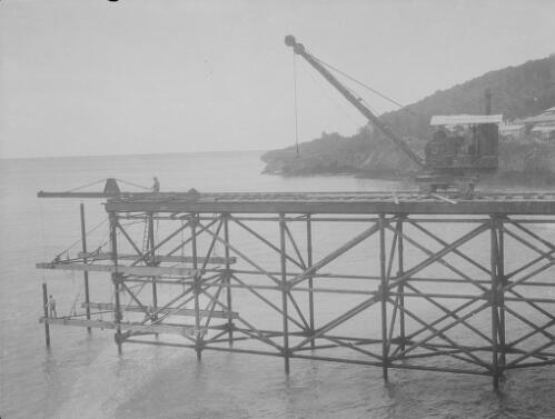 Workmen and crane during the construction of Christmas Island Phosphate Company pier, Christmas Island, approximately 1927, 5