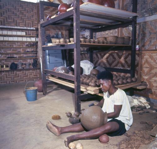 A potter working on a large pot, Madang, Papua New Guinea, approximately 1968 / Robin Smith