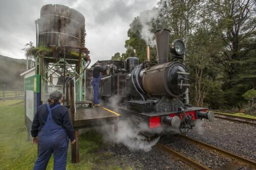 West Coast Wilderness Railway stoker Kara Barker and train driver Tony Rinaudo adding water to Mount Lyell No. 3 Abt class steam locomotive at Lynchford Station, Tasmania, 10 August 2019 / Greg Power