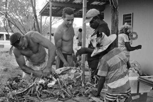 Australian Aboriginal men and a child dividing up turtle meat, Gulf of Carpentaria, Australia, 2014 / Hamish Cairns
