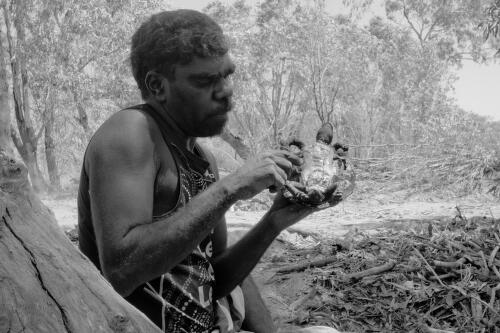 Australian Aboriginal man holding a cooked turtle, Gulf of Carpentaria, Australia, 2014 / Hamish Cairns