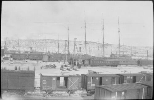 Railway trains and ships at jetty viewed from the Huntsend, Murmansk, Russia, 1918 / Michael Terry