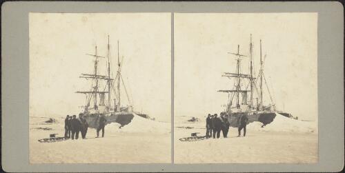 Members of the expedition and crew standing on sea ice in front of the docked Nimrod at Cape Royds landing site, Ross Island, Antarctica, February 1908 / T. W. Edgeworth David