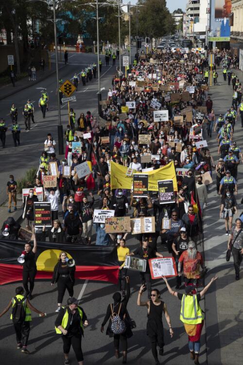 Police officers surrounding a large group of protesters marching with banners and signs along Wellington Street during the Black Lives Matter protest rally, Perth, Western Australia, 2020 / Philip Gostelow